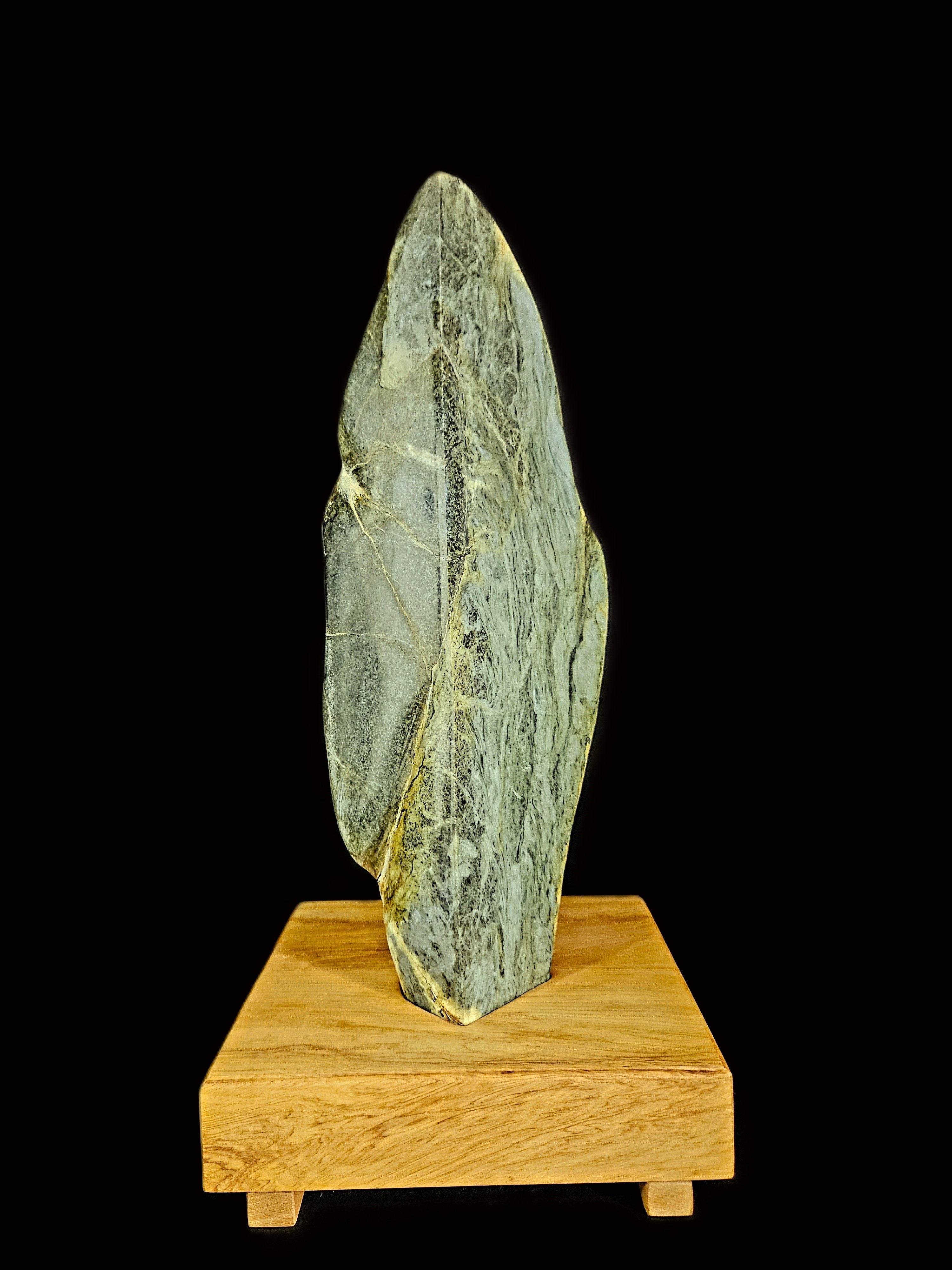 Freeform jade touchstone mounted on a rimu base